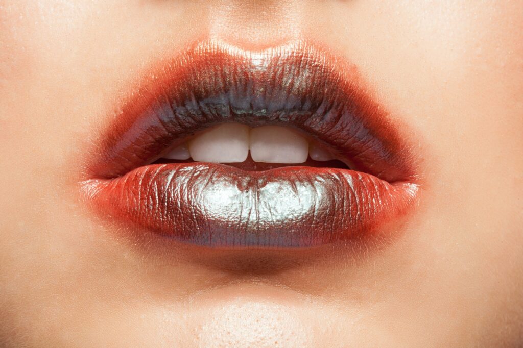 Close up view of beautiful woman lips with orange lipstick